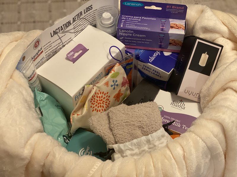 Inside a Basket of Healing: lanolin cream, nursing pads, herbal tea, wipes, a washcloth and the Lactation After Loss guide nestled in a blanket