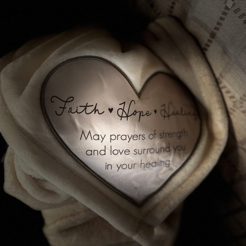 Close-up of the basket's cream blanket with an embroidered heart reading Faith, Hope, Healing: may prayers of strength and love surround you in your healing